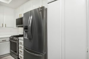 Kleiner Aktivkohlebehälter steht im Kühlschrank zwischen Lebensmitteln