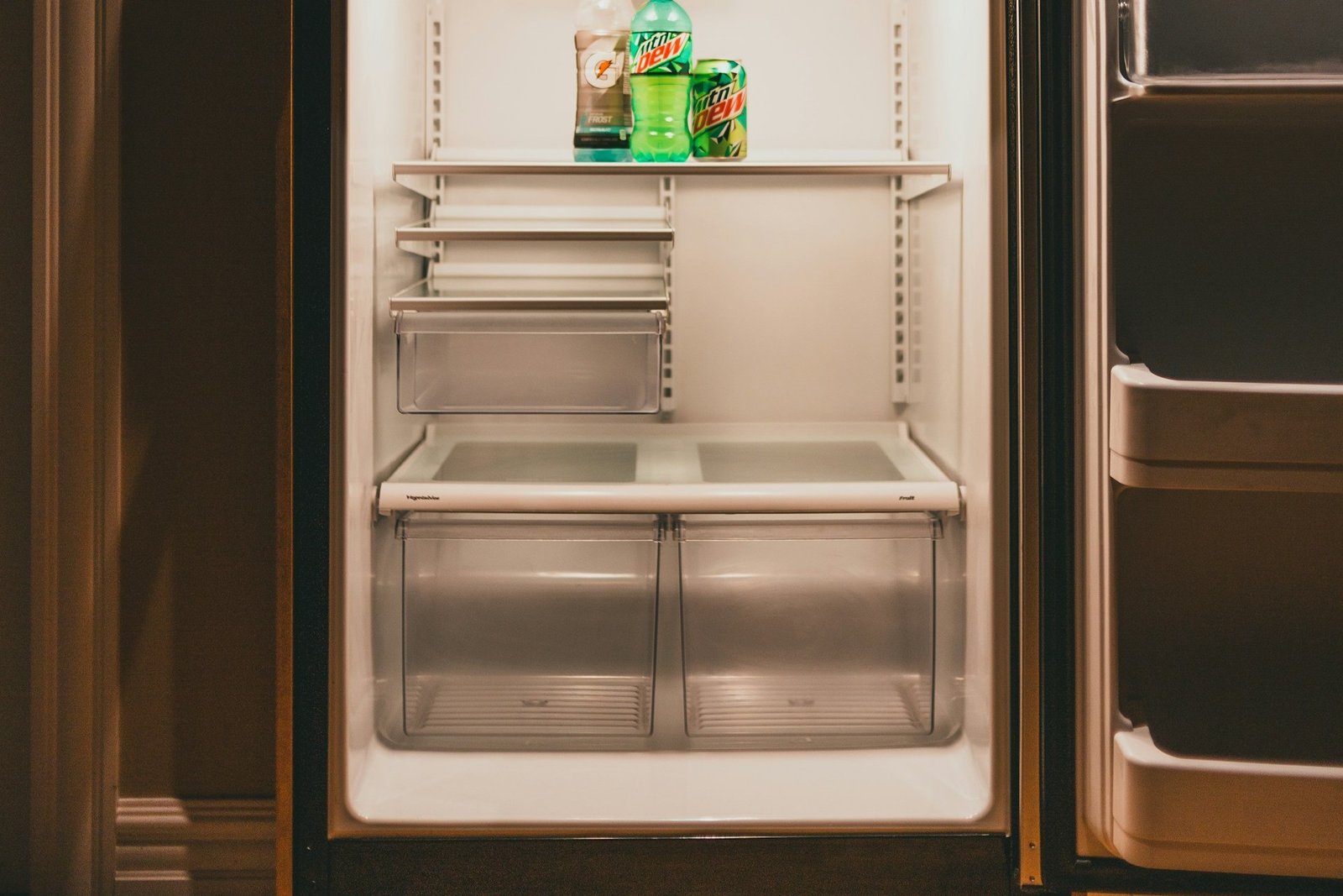 Kleine Abflussöffnung an der Rückwand eines Kühlschranks wird mit einem Stäbchen gereinigt