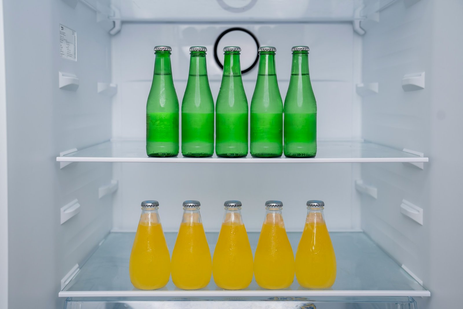 Verschüttete Flüssigkeit wird im Kühlschrank mit einem Tuch aufgewischt