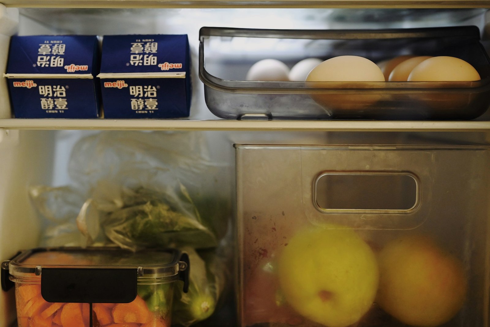 Verschiedene Lebensmittel stehen im geöffneten Kühlschrank